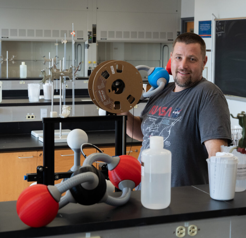 Photo of Prof. Kuhar with large-scale molecular models